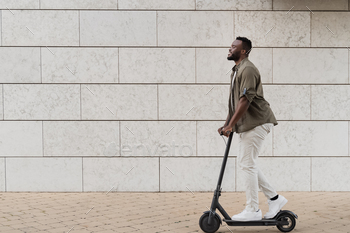 Young african american man using electric scooter outdoor in the city - Focus on face / Photodune, Misc