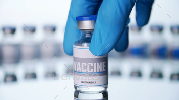 Close up, Scientist is holding a glass vial for vaccine in laboratory. / Photodune, Misc