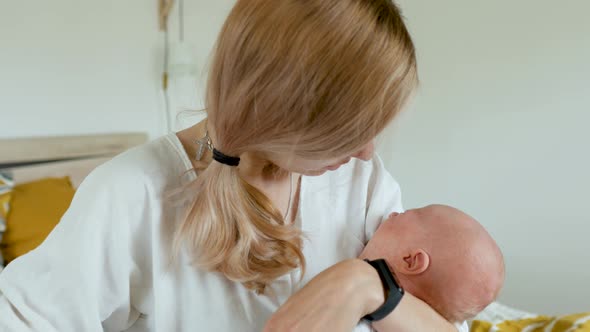 Caucasian mom calms a crying baby while holding in her arms