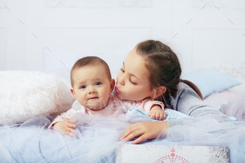 Happy little girl kisses little sister. The concept of family an / Photodune, Misc
