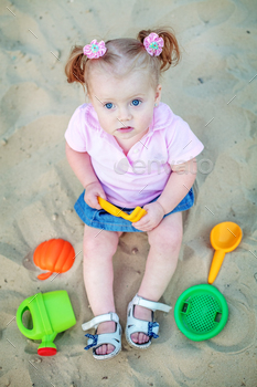Baby playing in the sand toys. The concept of childhood and development. / Photodune, Misc