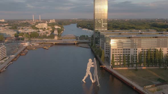 Berlin Aerial Drone shot of Molecule Man and Spree River toward Elsen Bridge at Sunset