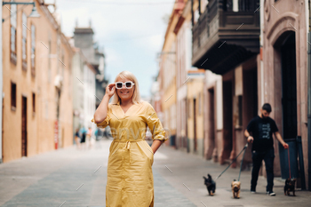a blonde woman in a yellow summer dress stands on the street of the Old town of La Laguna on the / Photodune, Misc