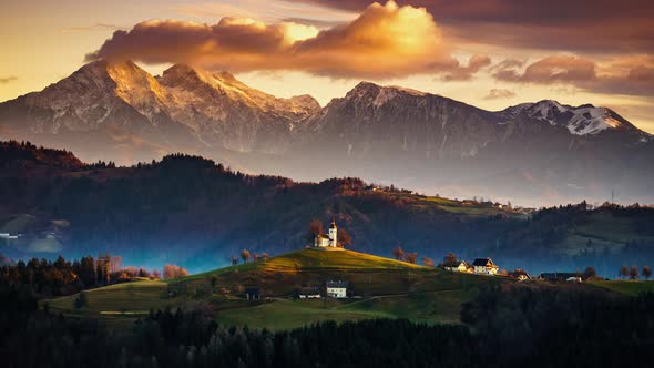 4K Timelapse Church of Saint Thomas at sunrise with Kamnisko Savinjske Alpe, Slovenia