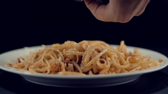 Cooking Spaghetti With Sause In Restaurant. Man Garnishing Delicious Pasta With Parmesan Cheese.