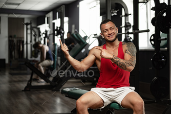 Portrait of man bodybuilder in red shirt in gym / Photodune, Misc