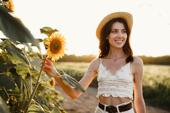 Young woman having a walk in sunflowers field in the morning / Photodune, Misc