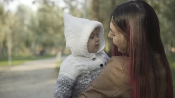 Portrait of Cute Charming Infant Looking Around As Mother Carrying Baby on Hands