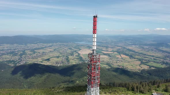 Aerial orbit shot of gsm tower transmitter on Skrzyczne Hill with Silesian Beskid and Żywieckie lake