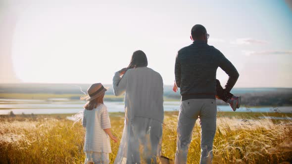 Young Family Standing on the Field and Looking Into the Distance