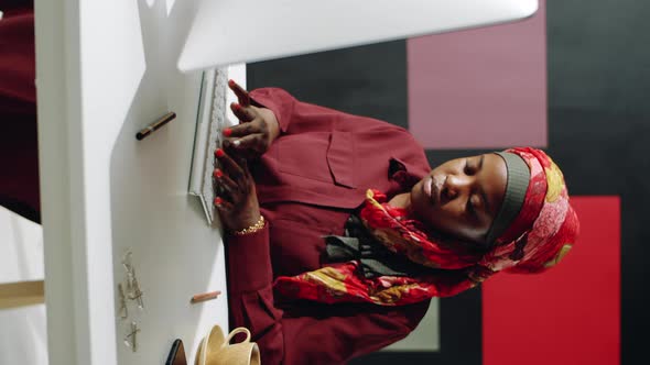 Muslim Woman in Red Using Computer Vertical