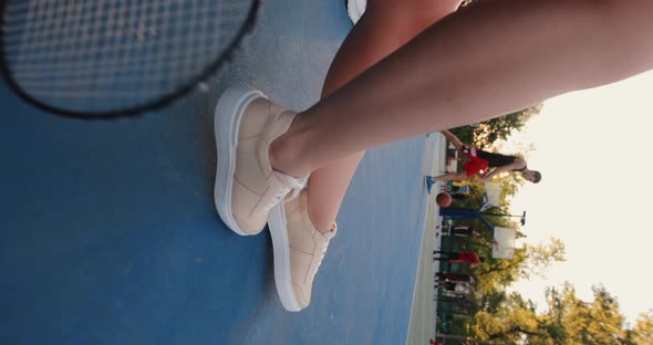 Female Legs Sitting on a Basketball Court Vertical Video