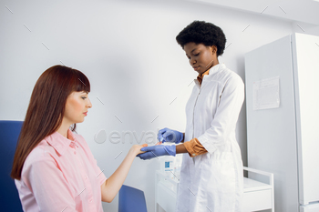 Pretty young Caucasian woman gives blood for analysis in modern light lab. Likable pleasant female / Photodune, Misc