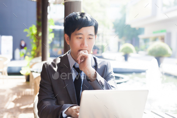 Young Asian casual businessman thinking while working in outdoor scene / Photodune, Misc