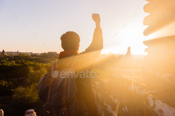 Young man raising hands up against sunlight - indicated success, achievement and victory . / Photodune, Misc