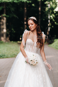 portrait of an elegant bride in a white dress with a bouquet in nature in a nature Park.Model in a / Photodune, Misc