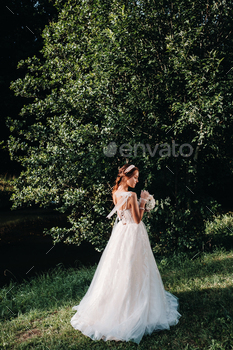 portrait of an elegant bride in a white dress with a bouquet in nature in a nature Park.Model in a / Photodune, Misc