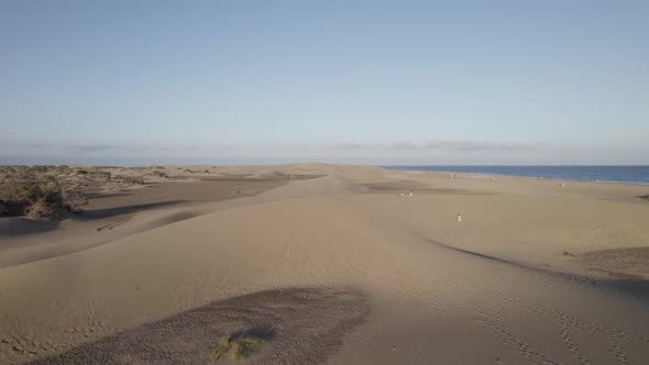 People walking at Maspalomas golden sand dunes, stunning sunset, Gran Canaria