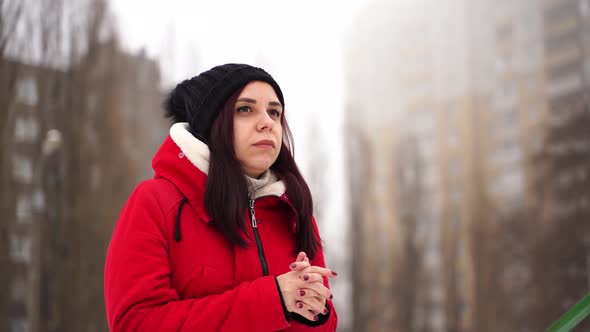 Young Woman in Hat and Red Jacket Standing on Street