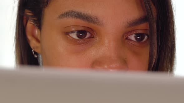 Brown Eyes of a Young Black Woman Working From Home Online