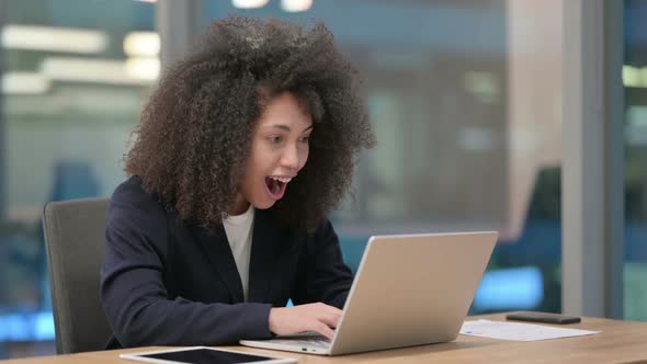 African Businesswoman with Laptop Celebrating Success