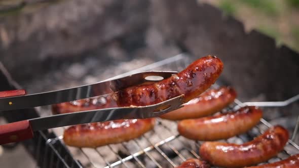 Closeup View of Tasty Sausages Grilling on Charcoal Grill Grate