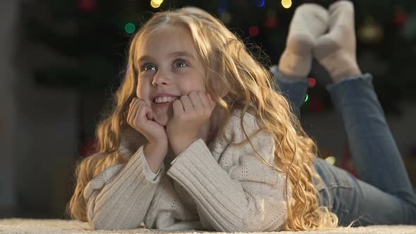 Cute Little Girl Dreaming About Gifts and Cheerful Celebration of Christmas, Joy