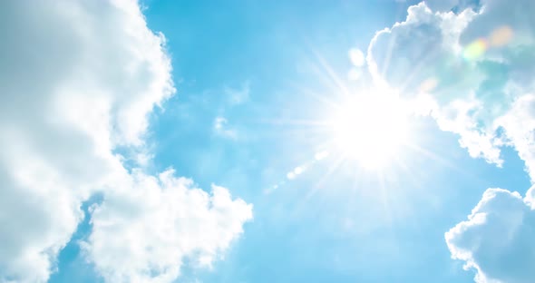 Time lapse of cloudscape with bright sun shining and revealing itself behind clouds.