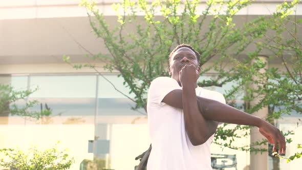 African American Man Stretching Arms in the City Street in the Morning