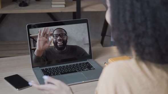 Girl/female Waving Hand To Video Conference Calling To Black Man, Online on Laptop Computer at Home