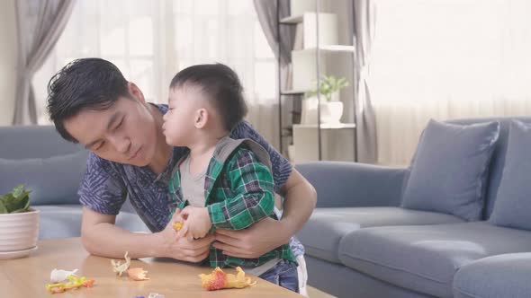 Asian Child Kiss His Young Father At Home