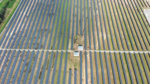 Aerial Top View on Solar Power Station in Green Field on Sunny Day. Solar Farm