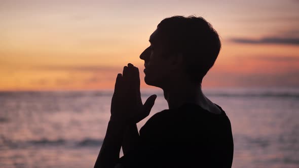 Silhouette of a Man Praying at Sunset Concept of Religion