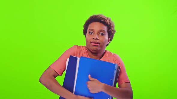 Black Woman with Frowns Face Holds Many Folders with Important Information