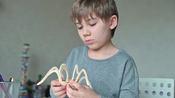 Close-up of a boy assembling a wooden toy from parts