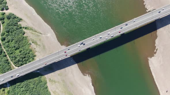 Aerial filming. Cars go over the bridge over the Tom river