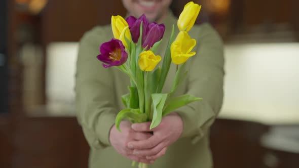 Live Camera Follows Bouquet of Flowers As Blurred Man Stretching Tulips Smiling Standing Indoors