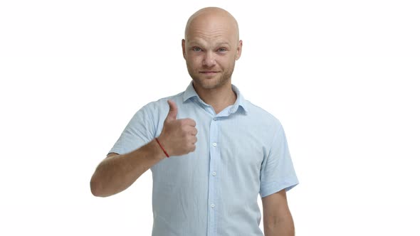 Happy Friendly Bald Guy with Beard Showing Thumbsup in Approval Winking and Sticking Tongue Silly