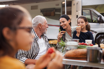 Multi-generation family sitting and eating outdoors by car, caravan holiday trip / Photodune, Misc