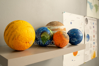 Group of planet models on shelf by white wall / Photodune, Misc