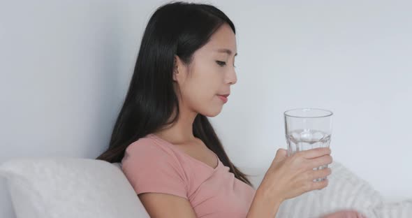 Woman taking pills and drinking glass of water