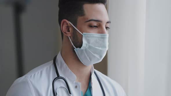 Male Pensive Thoughtful Arab Man Therapist Surgeon Wear White Uniform Medical Face Mask Standing at