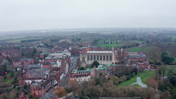 dolly forward aerial drone shot of Eton college Chapel and village on a cloudy day