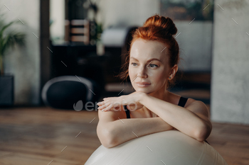 フィットボールに寄りかかって脇を見ている魅力的な女性のクローズアップ / Photodune, Misc
