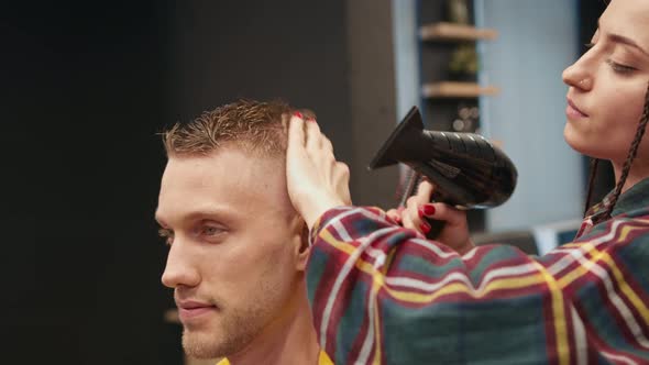 Barbershop: a woman barber shows a haircut to a man client, result of work