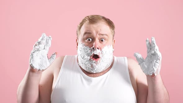 Upset Plump Man in White Undershirt with Foam on Beard