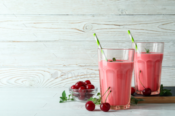 Glasses of cherry smoothie and ingredients on white wooden table / Photodune, Misc