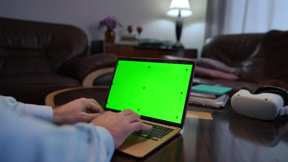 Closeup Green Screen Laptop with Male Hands Typing on Keyboard Indoors