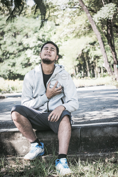 アジアの若い男性は、公園で運動中に心臓の痛みを持っています。 / Photodune, Misc