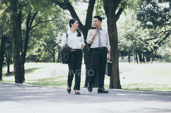 仕事を終えた後、公共の公園を歩いて話している幸せなアジアのビジネスの男性と女性。 / Photodune, Misc